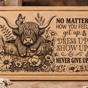 May include: A rectangular wooden cutting board featuring a laser-engraved illustration of a Highland cow sitting in a wooden bucket surrounded by flowers and butterflies. The text reads: NO MATTER HOW YOU FEEL get up, DRESS UP SHOW UP & NEVER GIVE UP.