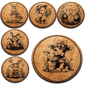 May include: Set of six wooden coasters with engraved Easter-themed designs. Each coaster features a different illustration of bunnies, eggs, and floral elements. The coasters are round with a dark brown border and a light brown wood grain.