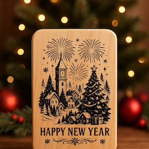 Può includere: Targa rettangolare in legno con un disegno inciso al laser raffigurante una scena di villaggio con fuochi d'artificio, un campanile e un albero di Natale. Le parole "HAPPY NEW YEAR" sono in basso.