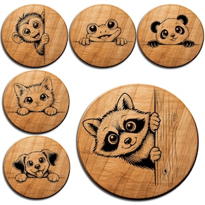 May include: A collection of six wooden coasters, each featuring a different animal design. The set includes a monkey, frog, panda, cat, raccoon, and dog. The coasters have detailed black line art on a light wood grain background.