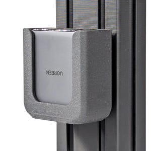 May include: A gray UGREEN power adapter is held in a gray plastic holder attached to a black metal rail.