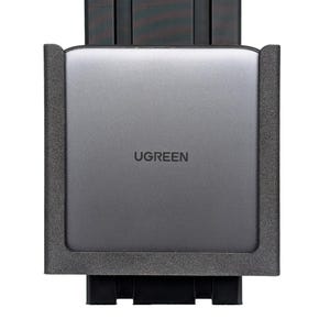 May include: A gray UGREEN device with the brand name printed on the front. The device is encased in a black frame and is mounted on a black base. The overall design is modern and sleek.