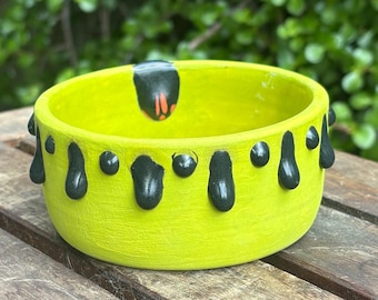 Bol de color verde lima con textura pegajosa negra