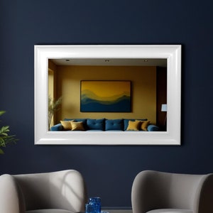 Può includere: Due poltrone grigie con un tavolino laterale in vetro blu in un soggiorno con uno specchio incorniciato bianco che riflette un soggiorno con un divano blu e un'opera d'arte gialla sul muro.