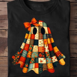 May include: Black t-shirt featuring a colorful patchwork ghost design. The ghost has an orange bow and is made of various patterned fabric squares in shades of orange, red, blue, and yellow. The design is centered on the shirt.