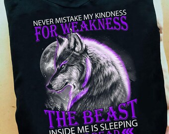 Puede incluir: Camiseta negra con un gráfico de lobo morado y el texto "Nunca confundas mi amabilidad con debilidad. La bestia que llevo dentro está durmiendo, no muerta."