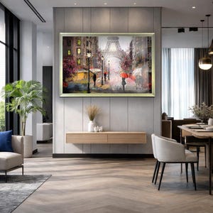 May include: A framed painting of a Parisian street scene with the Eiffel Tower in the background. The artwork depicts figures with umbrellas walking along a wet street, with buildings and streetlights lining the road. The painting is displayed in a modern living room.