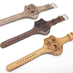 May include: Three leather watch straps featuring an owl design. The straps are brown, dark brown, and light brown. Each strap has a silver buckle.