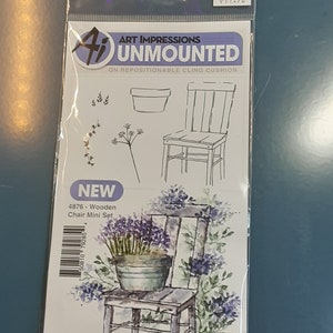 May include: A clear plastic package containing an Art Impressions unmounted stamp set. The set includes line drawings of a chair, a flower pot, and floral elements. The package features a watercolor illustration of a chair with a pot of lavender.