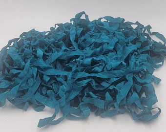 May include: A pile of teal blue ribbon, perfect for crafting and DIY projects.