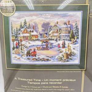 May include: A counted cross stitch kit titled A Treasured Time featuring a winter scene with snow-covered houses, a frozen pond, people ice skating, and a dog. The packaging includes the text A Treasured Time, Un moment précieux, Tiempos para recordar, and Design by Dennis P. Lewan.