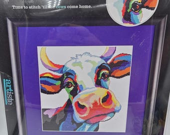 May include: Artiste counted cross-stitch kit featuring a colorful cow design. The packaging displays the text 'Time to stitch 'til the cows come home' and indicates a finished size of 12in x 12in. The kit includes a pattern, chart, and instructions.