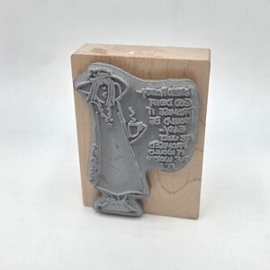 May include: A gray rubber stamp mounted on a wooden block. The stamp features a stylized illustration of a robed figure holding a cup, with text that reads "...would be easier..." and other text. The stamp is for crafts and art projects.