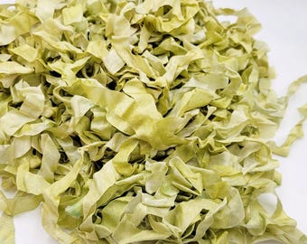 May include: A pile of green silk ribbon scraps, perfect for crafting and adding a touch of elegance to projects.