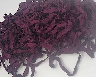 May include: A pile of deep purple fabric ribbon, perfect for crafting projects.