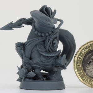 以下が含まれることがあります： 槍を持った生き物にまたがる戦士の灰色のミニチュアフィギュア。フィギュアは、テキストと肖像画のある金貨の隣にあります。フィギュアの高さは約3.8cmです。