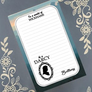 Peut inclure: Bloc-notes ligné avec le texte "In a world of Wickhams, be a Darcy." Le bloc-notes présente une silhouette dans un cadre orné et le nom "Brittany". Le fond a un effet aquarelle.