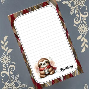 Puede incluir: Un bloc de notas rayado con un borde a cuadros rojo, marrón y blanco. Un perezoso de dibujos animados con una bufanda roja y una taza en la esquina. El nombre "Brittany" está escrito en cursiva.