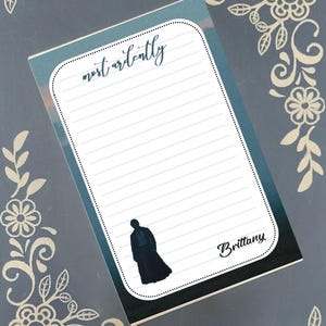 Peut inclure: Bloc-notes ligné avec l'inscription manuscrite « most ardently ». Il présente une silhouette d'une personne en long manteau et le nom « Brittany ». Le fond est un dégradé de bleu et de blanc. Motifs floraux.