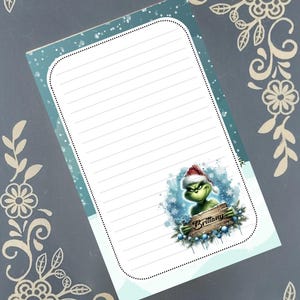 May include: A lined notepad with a teal border and a Grinch illustration wearing a Santa hat. The Grinch is holding a wooden sign that says "Brittany". The notepad has a dotted border and is decorated with snowflakes.