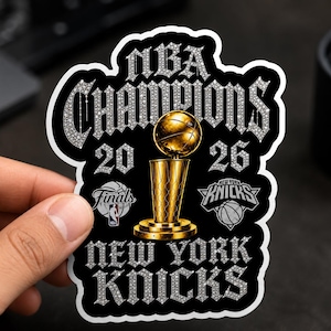 May include: A die-cut sticker featuring a gold basketball trophy centered between the years 20 and 26. The text NBA CHAMPIONS and NEW YORK KNICKS appears in a silver diamond-like font. Includes the NBA Finals logo and the New York Knicks logo.