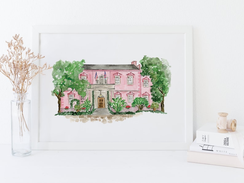 May include: Watercolor painting of a pink house with white trim and a green lawn. The house has a white door and a porch with a railing. There are two American flags flying from the roof.