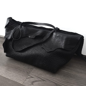 Grand sac avant-gardiste noir de style métropolitain audacieux en véritable cuir italien déchiré avec poches pour femmes indépendantes. Sac asymétrique