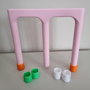 Puede incluir: Protectores de patas de muebles de plástico rosa con tapas naranja, verde y blanca. Los protectores están diseñados para evitar arañazos en los pisos.