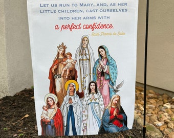 Könnte beinhalten: Eine weiße Gartenflagge mit einem Zitat von  Heiligen Franz von Sales über Maria. Das Zitat lautet: "Lasst uns zu Maria laufen, und, wie ihre kleinen Kinder, uns in ihre Arme werfen mit einem vollkommenen Vertrauen." Die Flagge zeigt ein Bild von Maria mit mehreren anderen Frauen in blauen und roten Roben.