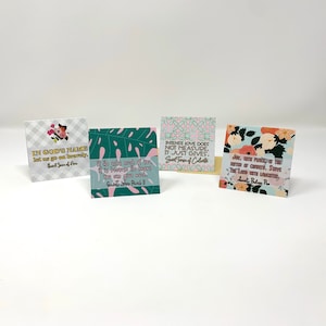May include: Four colorful cards with floral patterns and inspirational quotes. The quotes are: "In God's name let us go on bravely", "If he asks much of you, it is because he knows you can give much", "Intense love does not measure. It just gives", "Joy, with peace, is the better of country. Serve the Lord with laughter."