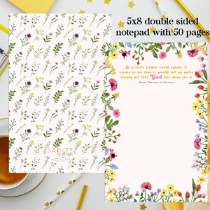 May include: A double-sided notepad with a floral design. The front features a white background with a repeating pattern of small flowers and leaves. The back features a pink background with a border of flowers and the quote "If a little flower could speak, it seems to me that it would tell us quite simply all that God has done for it." - Saint Therese of Lisieux.
