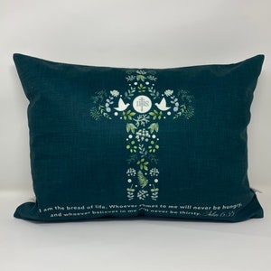 May include: A dark green throw pillow with a white cross design featuring a floral pattern and the words "I am the bread of life. Whoever comes to me will never be hungry, and whoever believes in me will never be thirsty. John 6:35"