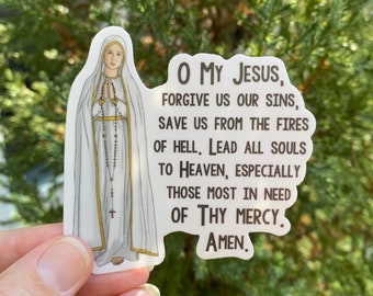 May include: A white sticker with a drawing of the Virgin Mary in a white dress and blue cloak. The sticker has a prayer to Jesus printed on it that reads: "O My Jesus, Forgive us our sins, Save us from the fires of hell, Lead all souls to Heaven, especially those most in need of Thy Mercy. Amen."