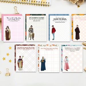 May include: Set of 10 inspirational quote notepads featuring colorful illustrations of saints. Each notepad has a different quote and saint. The quotes include: "The world is thy ship and net thy home", "In God's name let us go on bravely", "Always be close to Jesus, that is my life plan", "Our heart is made to love and there around us God", "Our health were made for thee, O God, and they who were taken will they tell in you", "Start being brave about everything", "The soldier is a man of faith, because by faith and by prayer he does what he wouldn't be able to do without them."