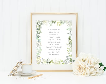 May include: A framed print with a gold frame featuring the text "I promise to be faithful to you..." surrounded by a watercolor floral border. A cup of coffee, a pen, and a bouquet of white flowers are in the foreground.