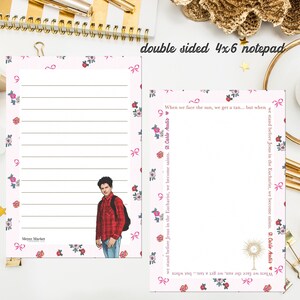 May include: A double-sided 4x6 inch notepad featuring a pink border with floral and bow patterns. One side has horizontal lines and an illustration of a person in a red plaid shirt. The other side features text and a gold monstrance illustration.