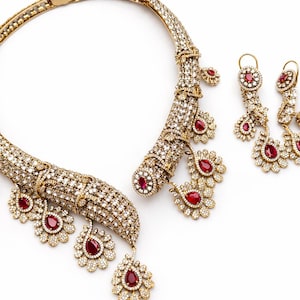 Conjunto nupcial de collar gargantilla y pendientes chapados en oro con circonitas rojas.