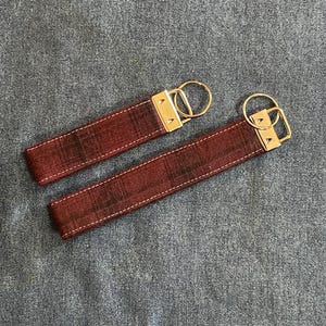 May include: Two red and black plaid keychains with gold metal key rings.