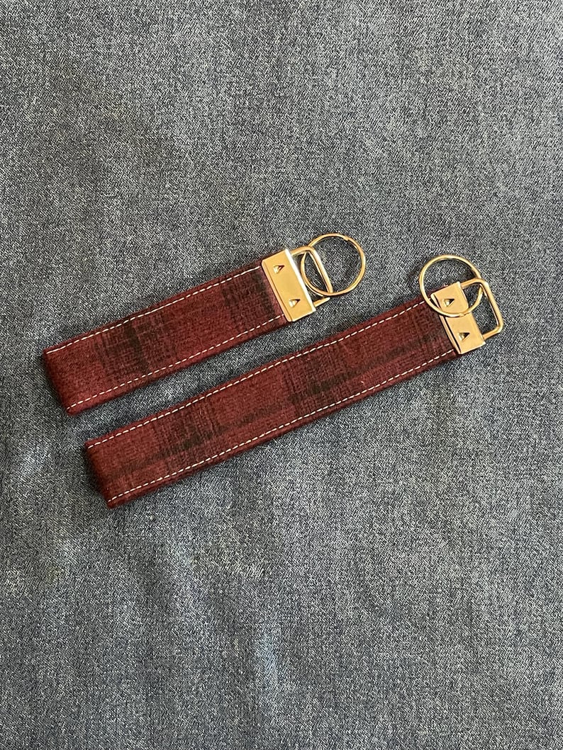 May include: Two red and black plaid keychains with gold metal key rings.