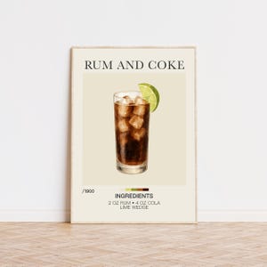 May include: A framed print showing a Rum and Coke cocktail illustration. The drink is in a tall glass with ice and a lime wedge. The text "RUM AND COKE" is at the top, with the ingredients listed below: 2 fl oz rum, 4 fl oz cola, and a lime wedge.