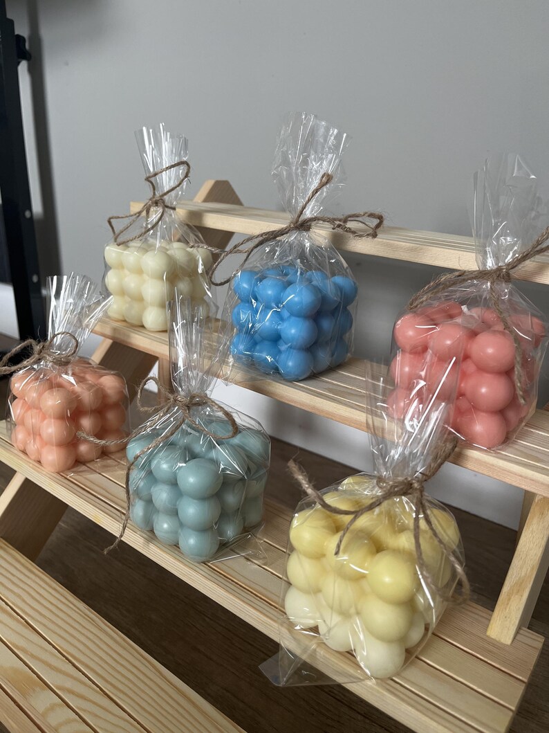 Six bubble cube candles in pastel colours, each wrapped in cellophane and tied with jute twine