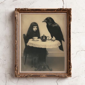 May include: Sepia-toned framed print depicting a young person and a raven at a table set for tea. The table has a lace cloth, and a teacup and teapot are visible. The frame is gold-coloured and ornate. The overall aesthetic is gothic.