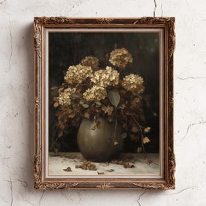 May include: A framed vintage still life painting featuring a vase of dried hydrangeas. The vase is a muted green, and the flowers are a mix of beige and brown. The ornate frame is a warm, antique gold color, adding to the painting's classic aesthetic.