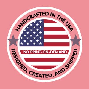 American flag with 'Handcrafted in the USA' text on a pink background. An American Flag circle design that boasts "Handcrafted in the USA - Designed, Created, and Shipped." No print on demand.