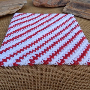 May include: Red and white striped crocheted dishcloth. The dishcloth is made with a diagonal pattern.