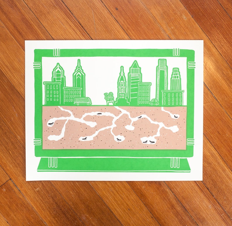 May include: A green framed illustration of a city skyline with a brown ant colony underneath. The city skyline includes several buildings and a car. The ant colony is made up of tunnels and chambers.