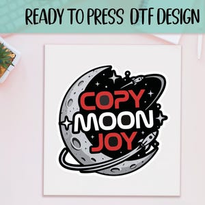 May include: A white square with a colorful graphic design featuring a crescent moon, stars, and rockets. The text "COPY MOON JOY" is in red and white. The words "READY TO PRESS DTF DESIGN" are at the top.