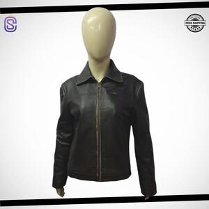 Könnte beinhalten: Eine braune Lederjacke mit Reißverschluss und Kragen. Die Jacke hat eine Tasche auf der linken Brust und zwei Taschen auf der Vorderseite.