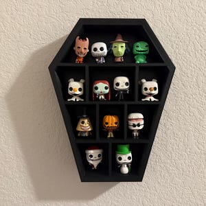 May include: Black coffin-shaped display case with 12 compartments, each holding a different character from the Nightmare Before Christmas. The characters are all in the popular Funko Pop! style.