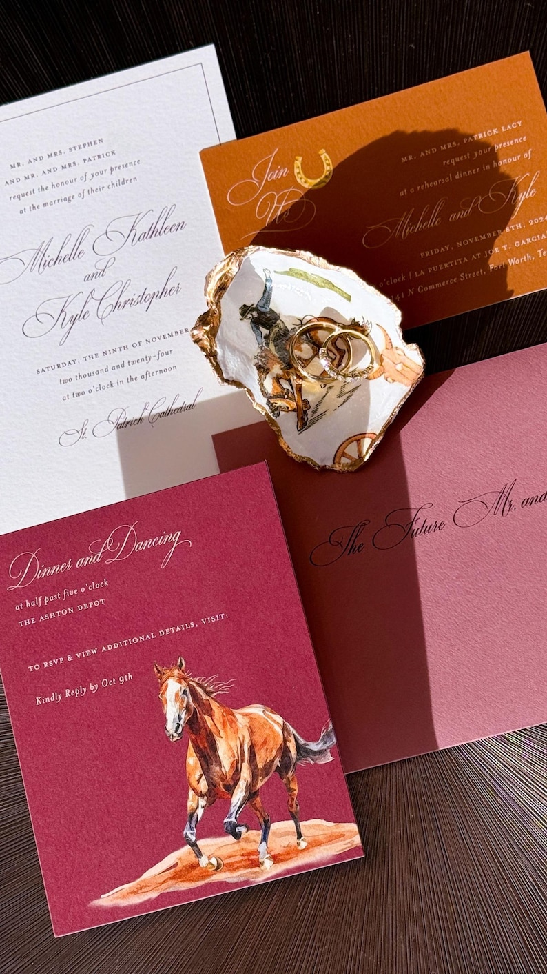 May include: Wedding invitation suite featuring a watercolor horse illustration, gold rings in a decorative dish, and various invitation cards with elegant calligraphy. The color palette includes burgundy, gold, and cream.